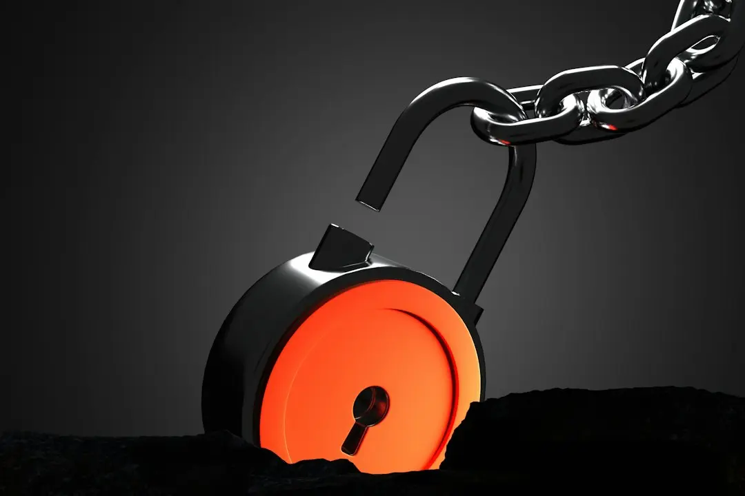 An open orange padlock on a chain against a dark background, a reminder to keep your Nufu TV login private